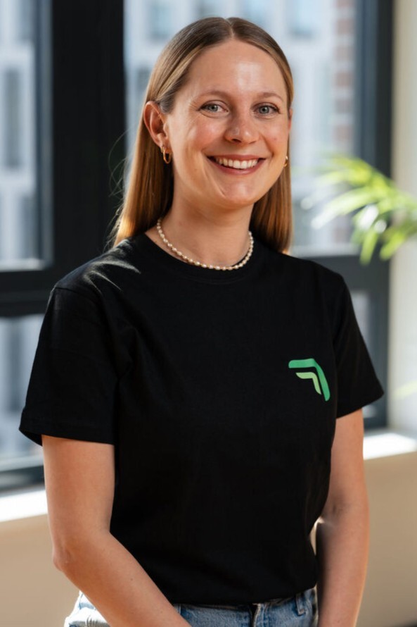 Vanessa König, Gründerin und CRO von summ.ai, lächelt in die Kamera, im Hintergrund ein Fenster und Pflanzen.